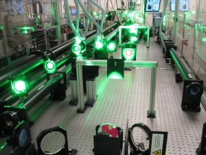 The gemini south amplifier showing various beam transport optics, beam tubes, and the Ti:Sa crystal. Green laser light can be seen from the pump laser.